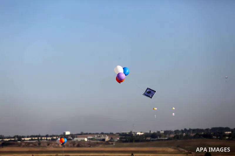 Balloons being flown by Palestinian children during a protest near tents at Gaza-Israel border, in Jabalia in the northern of Gaza Strip on June 27, 2018. Photo by Ashraf Amra