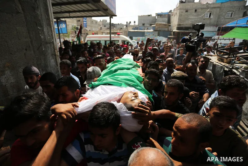 Mourners carry the body of Palestinian Abdul Fattah Abu Azoum 17, who was killed in Israeli tank fire earlier in the day, at the Israel-Gaza border, during his funeral in Rafah in the southern Gaza strip on June 28, 2018...