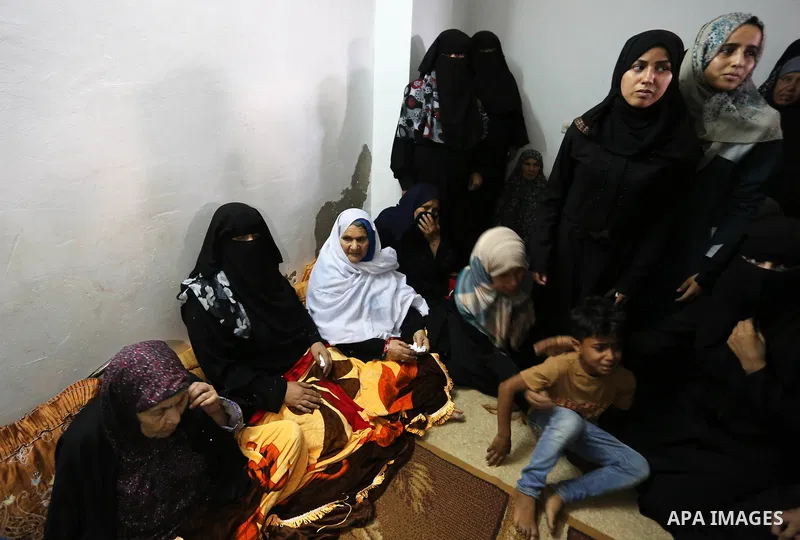 Relatives of Palestinian Abdul Fattah Abu Azoum 17, who was killed in Israeli tank fire earlier in the day, at the Israel-Gaza border, mourn during his funeral in Rafah in the southern Gaza strip on June 28, 2018. Photo...
