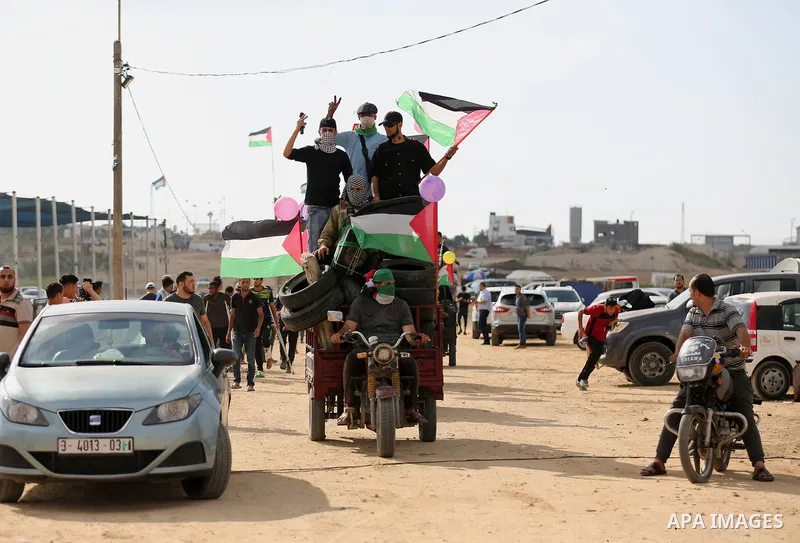 Palestinian protesters carry flags and tyres as they prepare to clashes with Israeli troops in tents protest where Palestinian demand the right to return to their homeland at the Israel-Gaza border, in east of Gaza City...