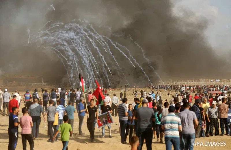 Palestinian protesters gather during clashes with Israeli troops in tents protest where Palestinian demand the right to return to their homeland at the Israel-Gaza border, in east of Gaza City on June 29, 2018. Photo by...