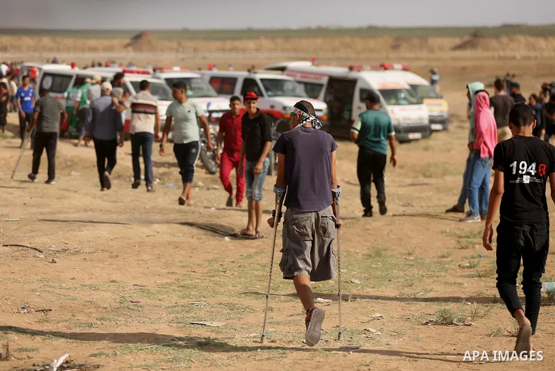 Palestinian protesters gather during clashes with Israeli troops in tents protest where Palestinian demand the right to return to their homeland at the Israel-Gaza border, in east of Gaza City on June 29, 2018. Photo by...