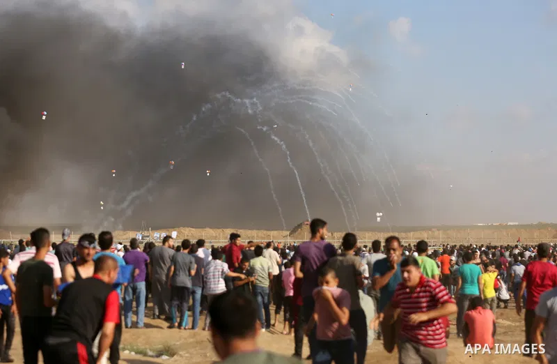 Palestinian protesters gather during clashes with Israeli troops in tents protest where Palestinian demand the right to return to their homeland at the Israel-Gaza border, in east of Gaza City on June 29, 2018. Photo by...