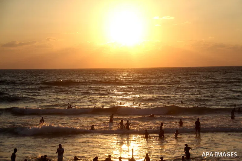 Palestinians swim to cool off in the Mediterranean Sea off the coast of Gaza City during sunset on June 29, 2018. Photo by Mahmoud Ajour