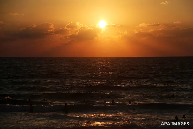 Palestinians swim to cool off in the Mediterranean Sea off the coast of Gaza City during sunset on June 29, 2018. Photo by Mahmoud Ajour