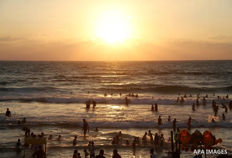 Palestinians swim to cool off in the Mediterranean Sea off the coast of Gaza City during sunset on June 29, 2018. Photo by Mahmoud Ajour
