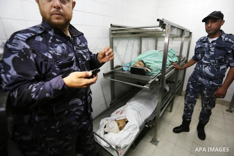 Palestinian security forces stand next to bodies of 14-year-old Yasser Abu Al-Naja and Mohammad Al-Hamayda who were killed by Israeli troops during clashes in tents protest where Palestinian demand the right to return to...