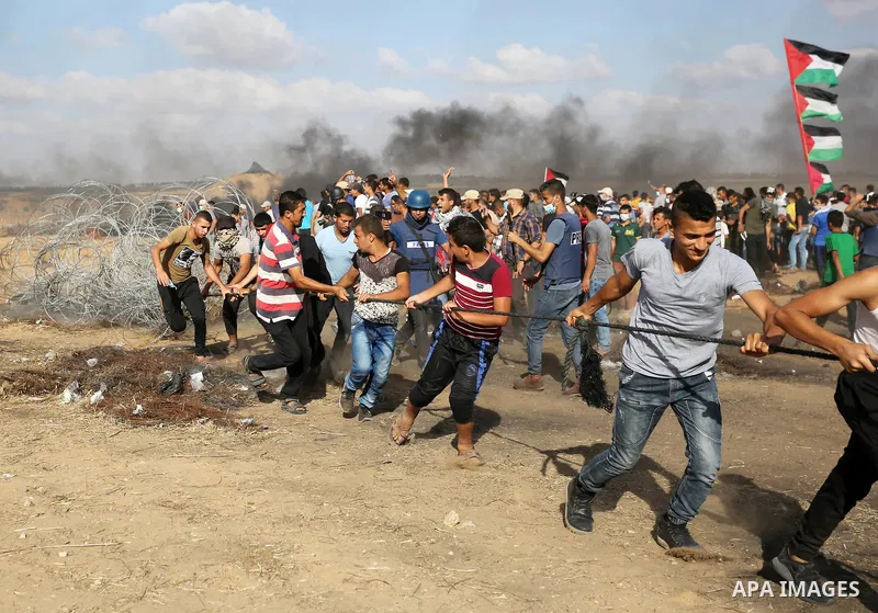 Palestinian protesters gather during clashes with Israeli troops in tents protest where Palestinian demand the right to return to their homeland at the Israel-Gaza border, in Khan Younis in the southern Gaza Strip on Jun...