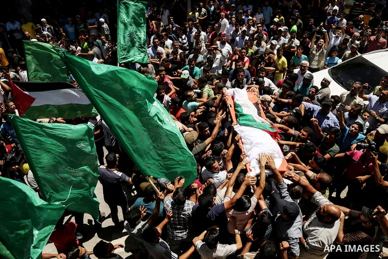 Mourners carry the body of 14-year-old Palestinian boy Yasser Abu Al-Naja, who was killed by Israeli troops during clashes in tents protest where Palestinian demand the right to return to their homeland at the Israel-Gaz...