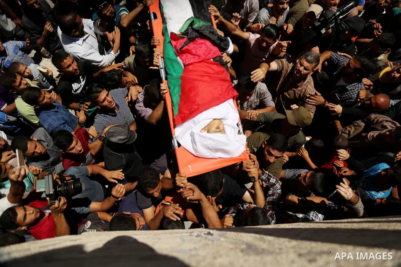 Mourners carry the body of 14-year-old Palestinian boy Yasser Abu Al-Naja, who was killed by Israeli troops during clashes in tents protest where Palestinian demand the right to return to their homeland at the Israel-Gaz...