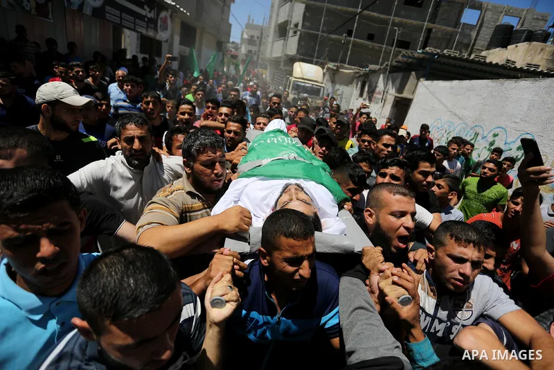 Mourners carry the body of 24-year-old Palestinian Mohammed al-Hamayda, who was killed by Israeli troops during clashes in tents protest where Palestinian demand the right to return to their homeland at the Israel-Gaza b...