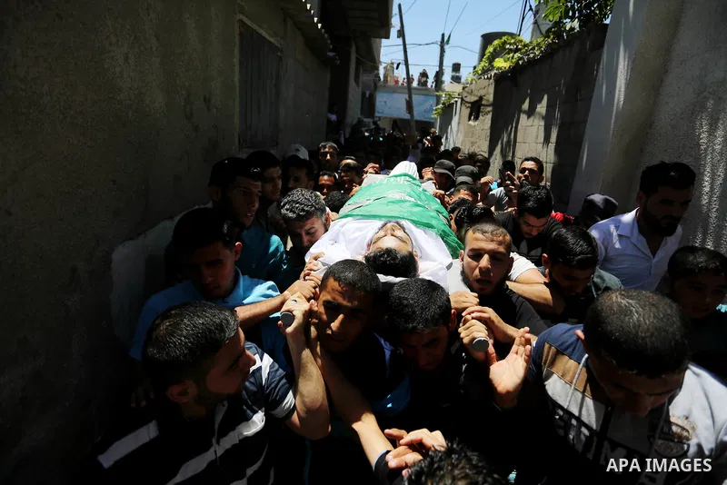 Mourners carry the body of 24-year-old Palestinian Mohammed al-Hamayda, who was killed by Israeli troops during clashes in tents protest where Palestinian demand the right to return to their homeland at the Israel-Gaza b...