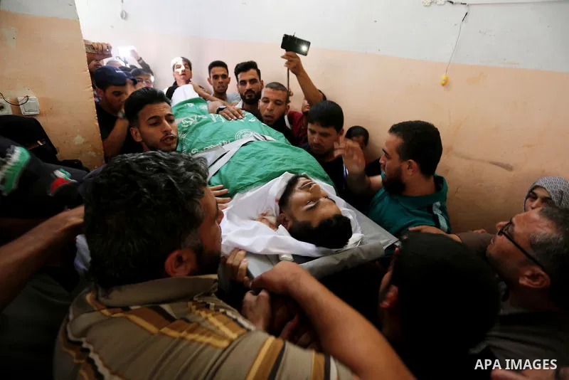 Mourners carry the body of 24-year-old Palestinian Mohammed al-Hamayda, who was killed by Israeli troops during clashes in tents protest where Palestinian demand the right to return to their homeland at the Israel-Gaza b...