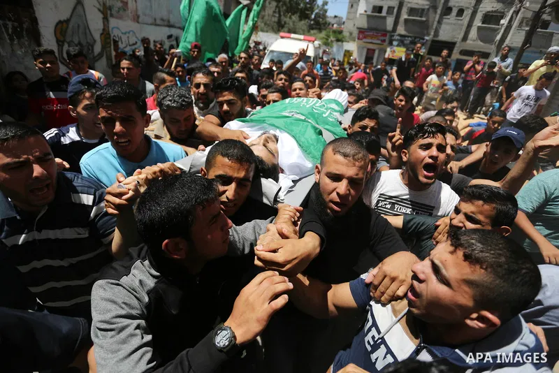Mourners carry the body of 24-year-old Palestinian Mohammed al-Hamayda, who was killed by Israeli troops during clashes in tents protest where Palestinian demand the right to return to their homeland at the Israel-Gaza b...
