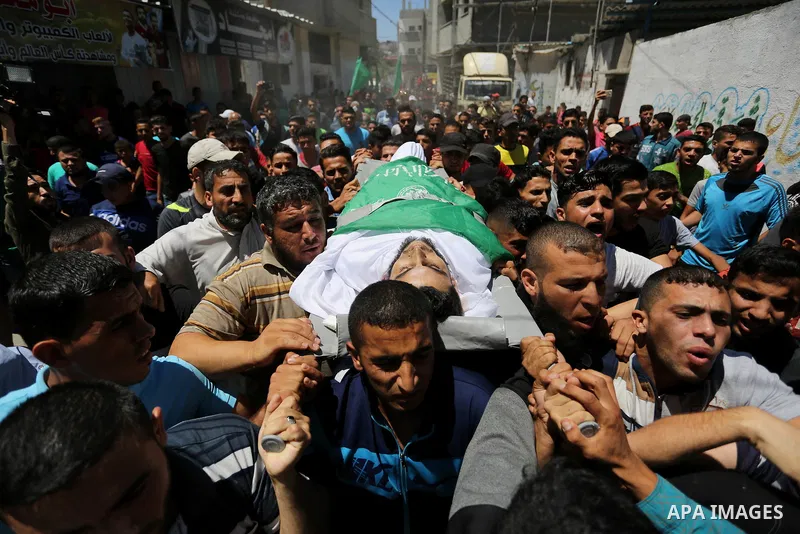 Mourners carry the body of 24-year-old Palestinian Mohammed al-Hamayda, who was killed by Israeli troops during clashes in tents protest where Palestinian demand the right to return to their homeland at the Israel-Gaza b...