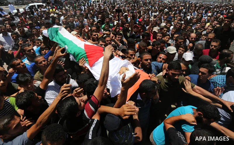 Mourners carry the body of 14-year-old Palestinian boy Yasser Abu Al-Naja, who was killed by Israeli troops during clashes in tents protest where Palestinian demand the right to return to their homeland at the Israel-Gaz...