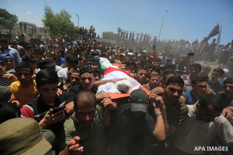 Mourners carry the body of 14-year-old Palestinian boy Yasser Abu Al-Naja, who was killed by Israeli troops during clashes in tents protest where Palestinian demand the right to return to their homeland at the Israel-Gaz...