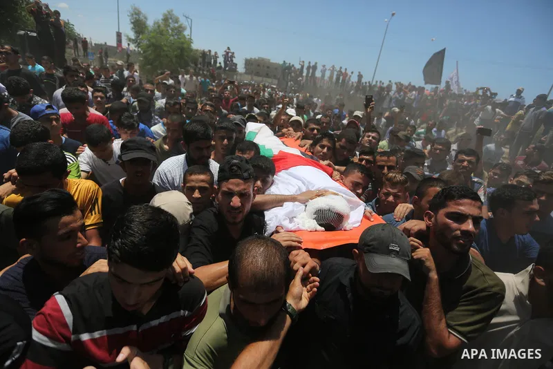 Mourners carry the body of 14-year-old Palestinian boy Yasser Abu Al-Naja, who was killed by Israeli troops during clashes in tents protest where Palestinian demand the right to return to their homeland at the Israel-Gaz...