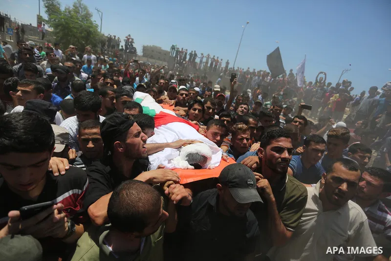 Mourners carry the body of 14-year-old Palestinian boy Yasser Abu Al-Naja, who was killed by Israeli troops during clashes in tents protest where Palestinian demand the right to return to their homeland at the Israel-Gaz...