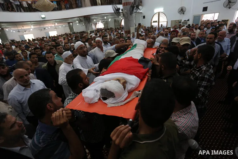 Mourners carry the body of 14-year-old Palestinian boy Yasser Abu Al-Naja, who was killed by Israeli troops during clashes in tents protest where Palestinian demand the right to return to their homeland at the Israel-Gaz...