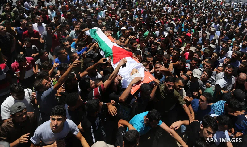 Mourners carry the body of 14-year-old Palestinian boy Yasser Abu Al-Naja, who was killed by Israeli troops during clashes in tents protest where Palestinian demand the right to return to their homeland at the Israel-Gaz...
