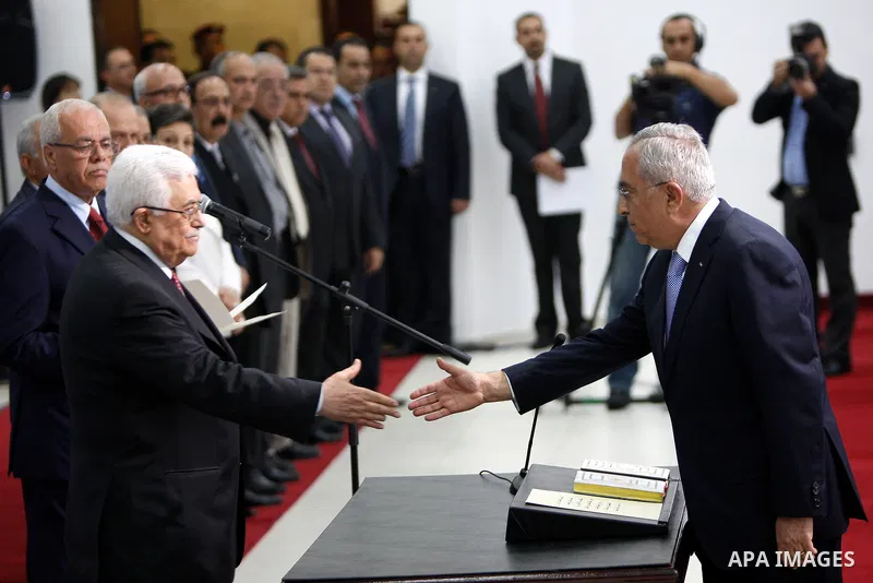 (FILES) This file photo taken on May 16, 2012 shows Palestinian President Mahmoud Abbas and his Prime Minister Salam Fayyad, receive the new government Ministers during the swearing in ceremony of the new cabinet, at Abb...