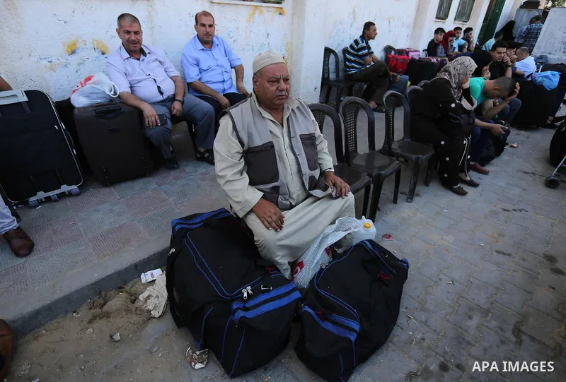 Palestinians wait for travel permits to cross into Egypt through the Rafah border crossing in Khan Yunis in the southern Gaza Strip on July 2, 2018. Photo by Ashraf Amra