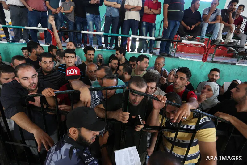 Palestinians wait for travel permits to cross into Egypt through the Rafah border crossing in Khan Yunis in the southern Gaza Strip on July 2, 2018. Photo by Ashraf Amra