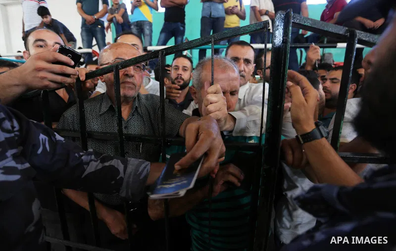 Palestinians wait for travel permits to cross into Egypt through the Rafah border crossing in Khan Yunis in the southern Gaza Strip on July 2, 2018. Photo by Ashraf Amra