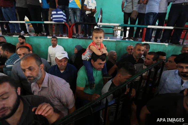 Palestinians wait for travel permits to cross into Egypt through the Rafah border crossing in Khan Yunis in the southern Gaza Strip on July 2, 2018. Photo by Ashraf Amra