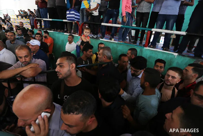 Palestinians wait for travel permits to cross into Egypt through the Rafah border crossing in Khan Yunis in the southern Gaza Strip on July 2, 2018. Photo by Ashraf Amra