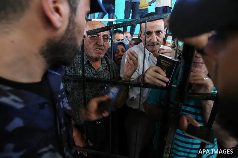 Palestinians wait for travel permits to cross into Egypt through the Rafah border crossing in Khan Yunis in the southern Gaza Strip on July 2, 2018. Photo by Ashraf Amra