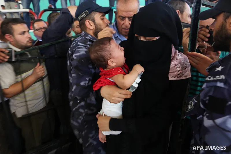 Palestinians wait for travel permits to cross into Egypt through the Rafah border crossing in Khan Yunis in the southern Gaza Strip on July 2, 2018. Photo by Ashraf Amra