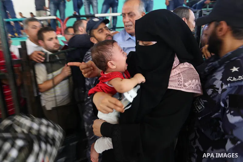 Palestinians wait for travel permits to cross into Egypt through the Rafah border crossing in Khan Yunis in the southern Gaza Strip on July 2, 2018. Photo by Ashraf Amra