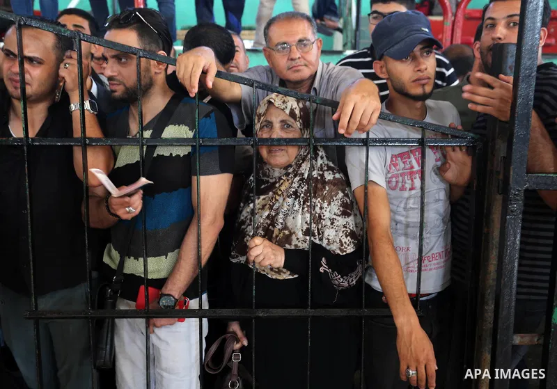 Palestinians wait for travel permits to cross into Egypt through the Rafah border crossing in Khan Yunis in the southern Gaza Strip on July 2, 2018. Photo by Ashraf Amra