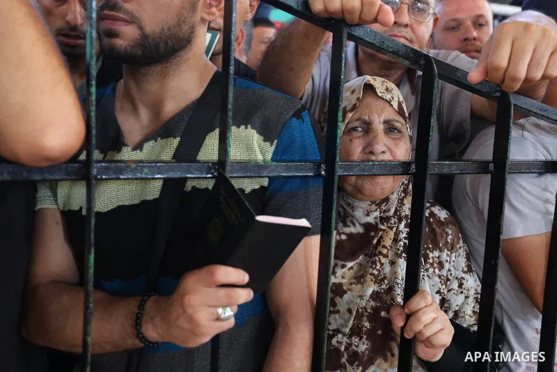 Palestinians wait for travel permits to cross into Egypt through the Rafah border crossing in Khan Yunis in the southern Gaza Strip on July 2, 2018. Photo by Ashraf Amra
