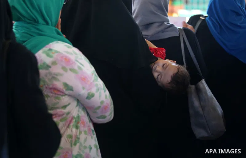 Palestinians wait for travel permits to cross into Egypt through the Rafah border crossing in Khan Yunis in the southern Gaza Strip on July 2, 2018. Photo by Ashraf Amra
