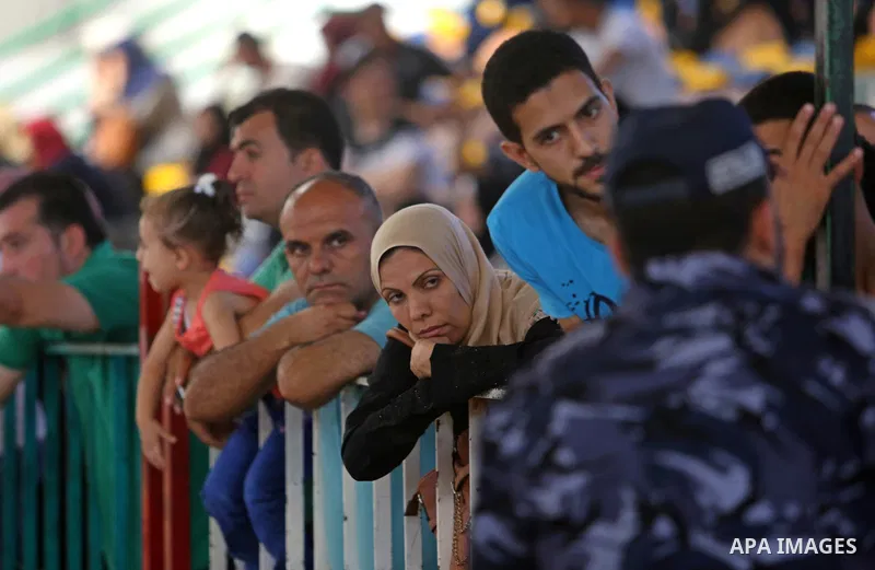 Palestinians wait for travel permits to cross into Egypt through the Rafah border crossing in Khan Yunis in the southern Gaza Strip on July 2, 2018. Photo by Ashraf Amra