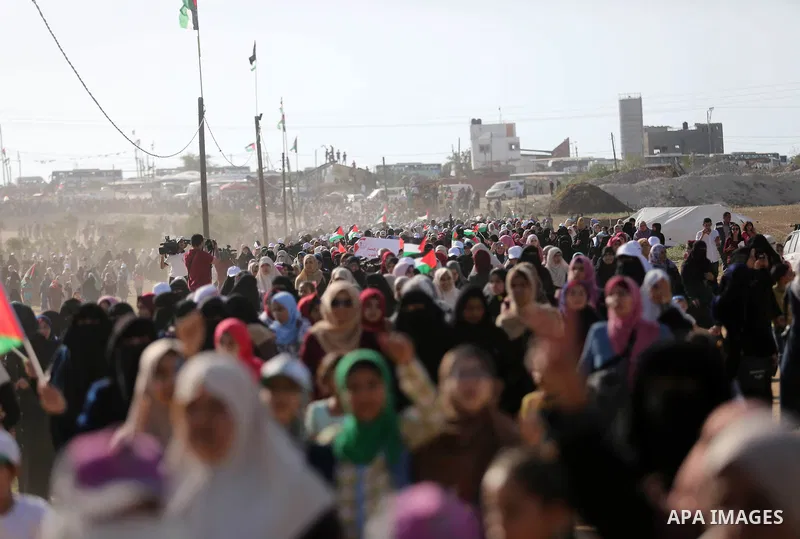 Palestinian women gather during a protest where Palestinians demand the right to return to their homeland along the border with Israel east of Gaza City on July 3, 2018. Photo by Ashraf Amra