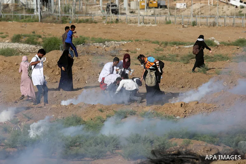 Palestinian medics help a female protester during a protest by Palestinian women where Palestinians demand the right to return to their homeland along the border with Israel east of Gaza City on July 3, 2018. Photo by As...