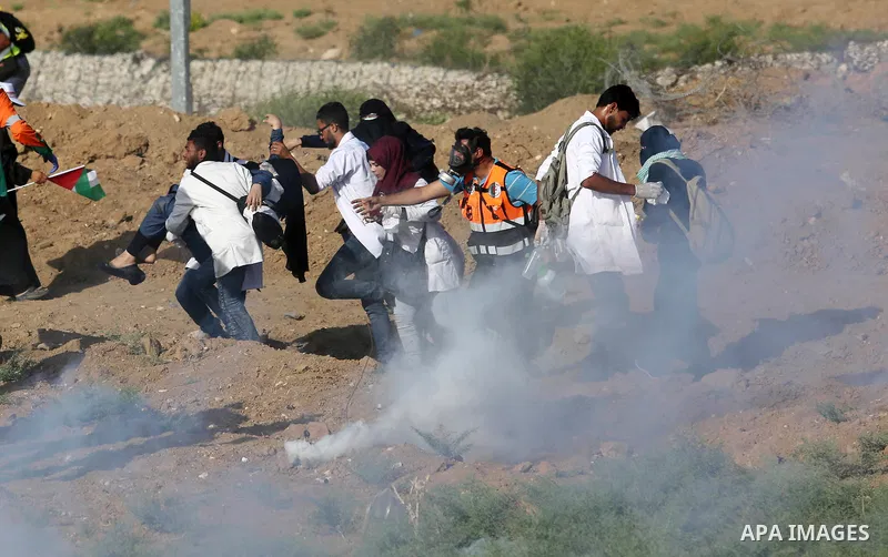 Palestinian Paramedics carry away an injured female protester during a protest by Palestinian women where Palestinians demand the right to return to their homeland along the border with Israel east of Gaza City on July 3...