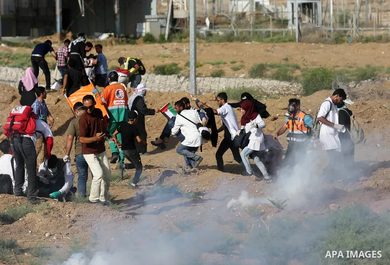 Palestinian Paramedics carry away an injured female protester during a protest by Palestinian women where Palestinians demand the right to return to their homeland along the border with Israel east of Gaza City on July 3...