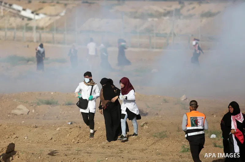Palestinian medics help a female protester during a protest by Palestinian women where Palestinians demand the right to return to their homeland along the border with Israel east of Gaza City on July 3, 2018. Photo by As...