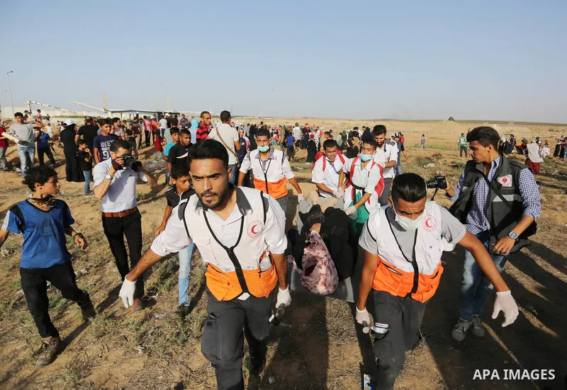Palestinian Paramedics carry away an injured female protester during a protest by Palestinian women where Palestinians demand the right to return to their homeland along the border with Israel east of Gaza City on July 3...