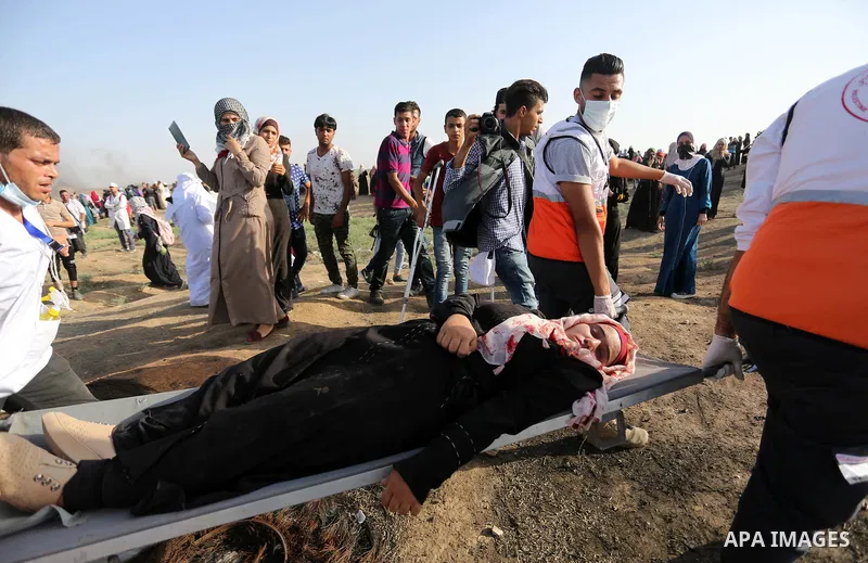 Palestinian Paramedics carry away an injured female protester during a protest by Palestinian women where Palestinians demand the right to return to their homeland along the border with Israel east of Gaza City on July 3...