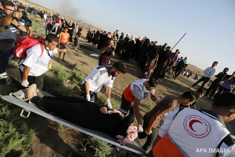 Palestinian Paramedics carry away an injured female protester during a protest by Palestinian women where Palestinians demand the right to return to their homeland along the border with Israel east of Gaza City on July 3...