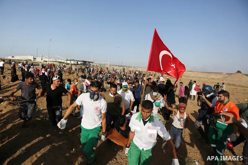 Palestinian Paramedics carry away an injured protester during a protest by Palestinian women where Palestinians demand the right to return to their homeland along the border with Israel east of Gaza City on July 3, 2018....