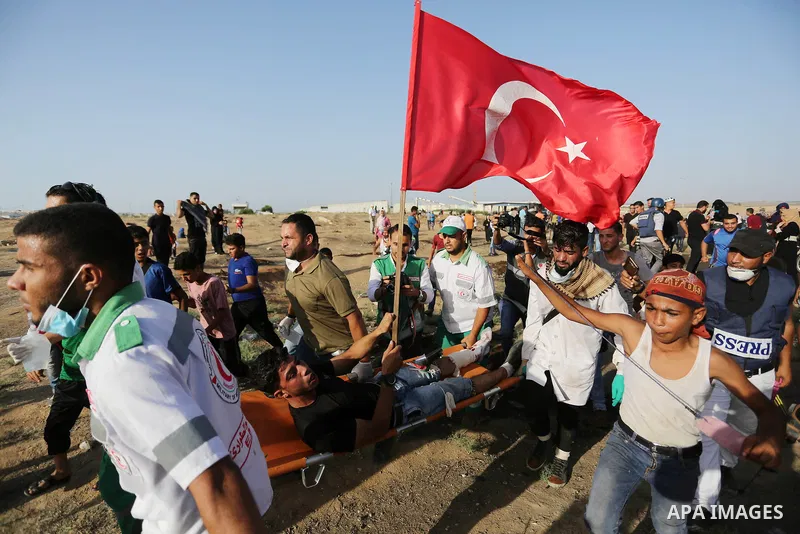 Palestinian Paramedics carry away an injured protester during a protest by Palestinian women where Palestinians demand the right to return to their homeland along the border with Israel east of Gaza City on July 3, 2018....