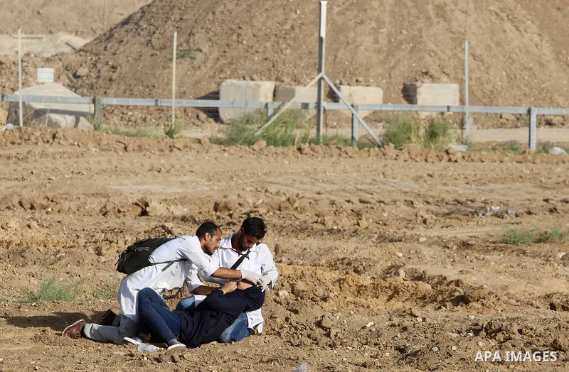 Palestinian medics help a female protester during a protest by Palestinian women where Palestinians demand the right to return to their homeland along the border with Israel east of Gaza City on July 3, 2018. Photo by At...