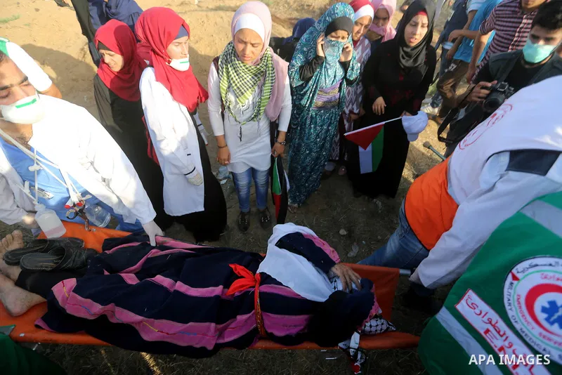 Palestinian Paramedics carry away an injured female protester during a protest by Palestinian women where Palestinians demand the right to return to their homeland along the border with Israel east of Gaza City on July 3...
